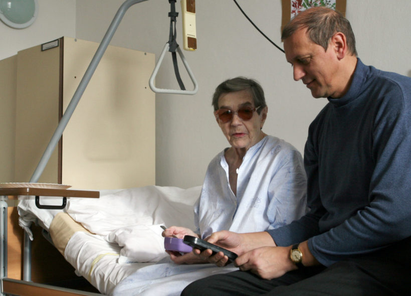 Petr Hartmann s pacientkou sedí na polohovacím lůžku. Foto:Robert Mročka