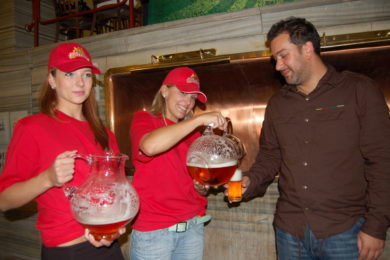 Hostestky třímají v rukou džbány se dvěma vzorky fotbalového piva a nalévají je na ochutnávce.