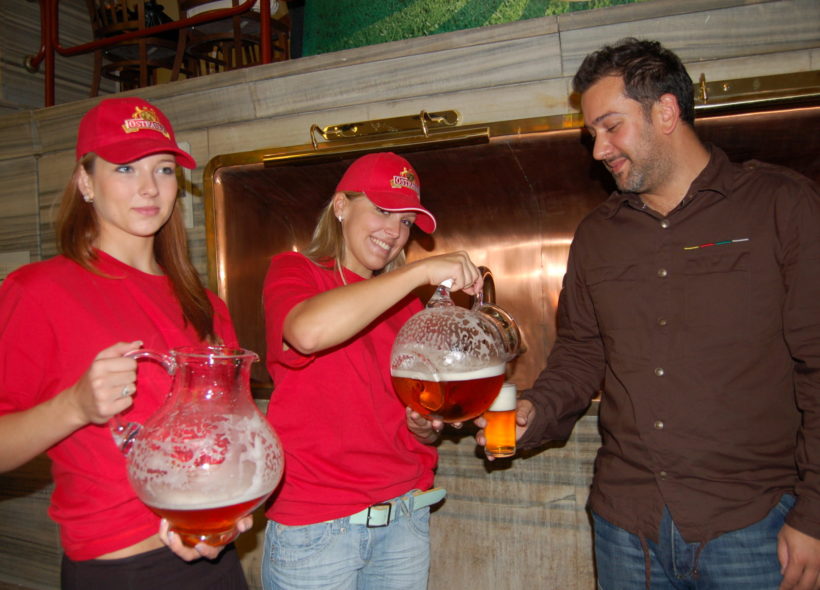 Hostestky třímají v rukou džbány se dvěma vzorky fotbalového piva a nalévají je na ochutnávce.