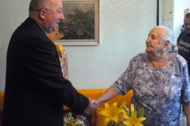 Stoletá Anna Bartová přijímá gratulaci od Petra Jedličky. 