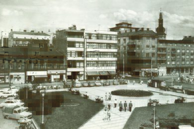 Pohled na náměstí koncem 60. let. Na ploše se dalo parkovat, centrem náměstí projížděly tramvaje a vlevo stály dva malé domky, které byly později zbourány, aby místo nich vyrostl obchodní dům Laso.