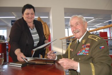 Brigádní generál Mikuláš Končický podepisuje knihu o osvobození. 