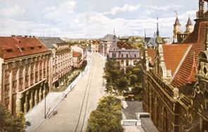Nádražní ulice kolem roku 1925. Vpravo je vidět portál Německého domu, vlevo stojí dodnes zachované budovy Anglo-českolovenské banky a Hornického domu s kavárnou Elektra, stavby za nimi již neexistují. 
