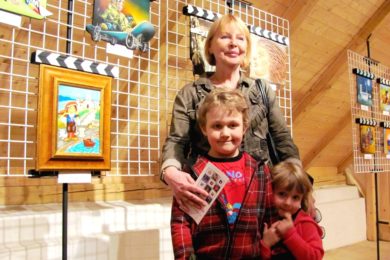 Vlasta Švejdová se svými vnoučaty u filmové klapky, kterou namalovala pro Zlínský filmový festival. 