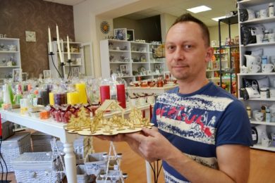Petr Světlík ukazuje dřevěný betlém, který obohatil vánoční sortiment prodejny Barevný svět. .