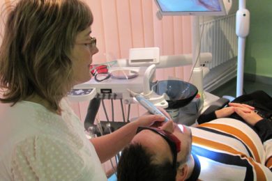 Popiska:  Dentální hygienistka Pavlína Hubíková ošetřuje pacienta ve své ordinaci.