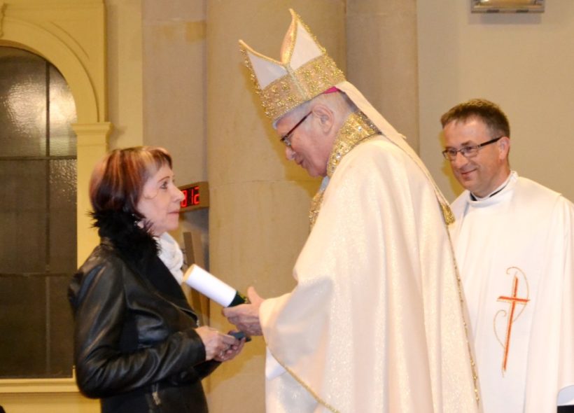 Biskup předává Ludmile Moniakové medaili sv. Hedviky a pamětní list.