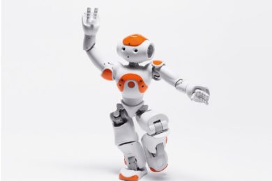 ři malí NAO roboti předvedou své taneční umění v synchronizované show.