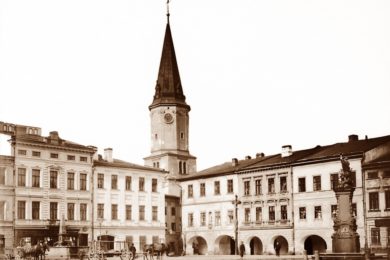 Snímek místeckého náměstí z roku 1908 s kašnou v levé části záběru.