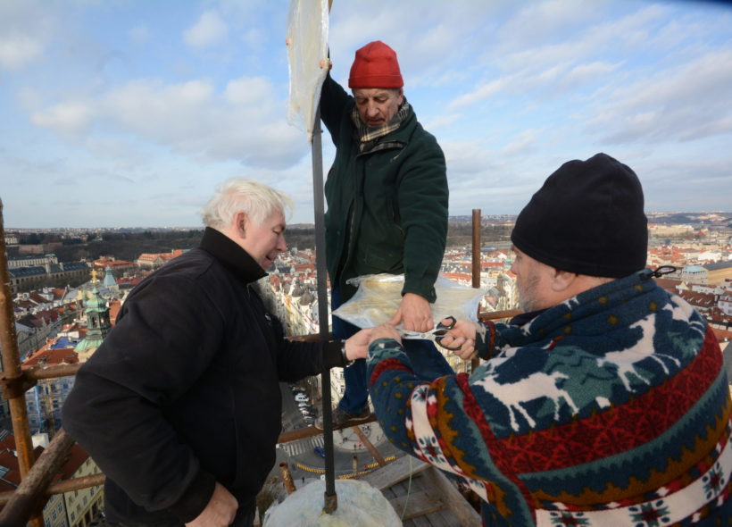 Restaurátoři Vladimír Pikl, Zdeněk Juppe a Pavel Filip  po uložení tubusů do makovic věže instalují hvězdu nad jednou z makovic.