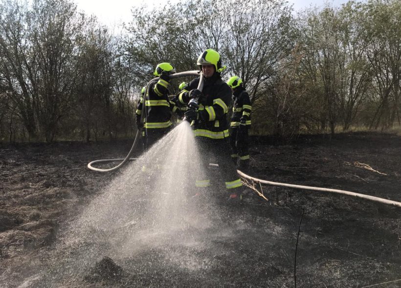 Vypalování trávy hrozí požárem. Na snímku likvidace ohně  v Dolních Měcholupech. Zdroj Hasiči Praha