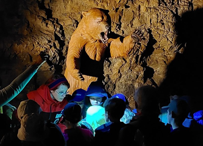 Medvěd Bruno provede děti jeskyní Výpustek v Moravském krasu.  