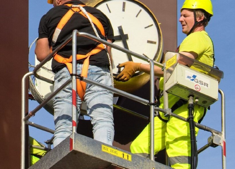 Pracovníci THMP usazují na Florenci opravené hodiny na plastiku času.