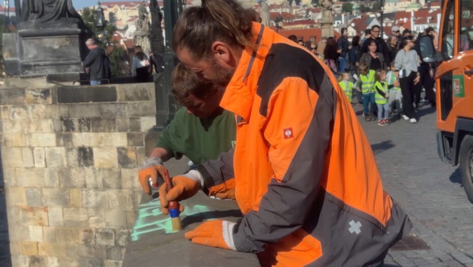 Pracovníci Technické správy komunikací odstraňují graffiti z Karlova mostu.