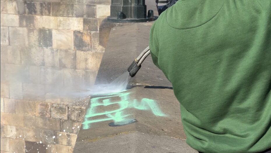 Pracovníci Technické správy komunikací odstraňují graffiti z Karlova mostu.