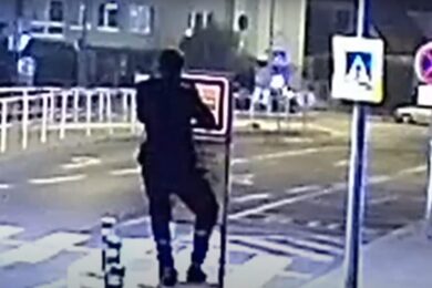 Sprejer vyšplhal na označení zastávky, které pak sříbrným sprejem postříkal.