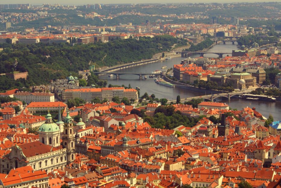 Praha — město, které si musí znovu začít stavět pro své obyvatele. Pohled na historické centrum s Vltavou a ikonickými mosty připomíná, že za krásou města se skrývá i výzva: jak zajistit dostupné bydlení, spravedlivou ekologii a energetickou stabilitu pro všechny, kdo tu skutečně žijí.