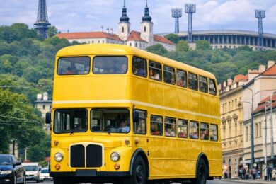 Historický žlutý berlínský doubledecker projíždí pražskými ulicemi s výhledem na Petřínskou rozhlednu a Strahovský klášter. Symbolicky připomíná Den veřejné dopravy, který letos slaví i Praha 6.