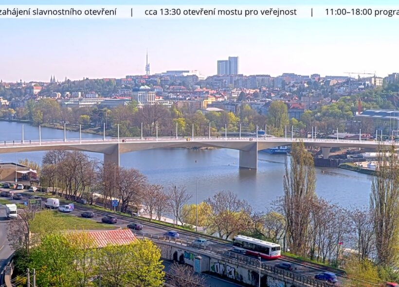 Záběr na Dvorecký most během dnešního slavnostního otevření. Kamera zachycuje provoz, okolní město i atmosféru programu u Vltavy.