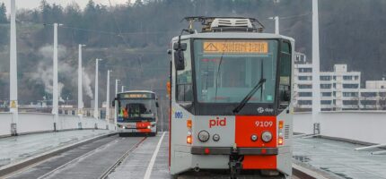 Tramvaj a autobus PID projíždějí po novém mostě v ranním provozu. Dvorecký most propojuje oba břehy Vltavy a stává se klíčovou tepnou pražské MHD.