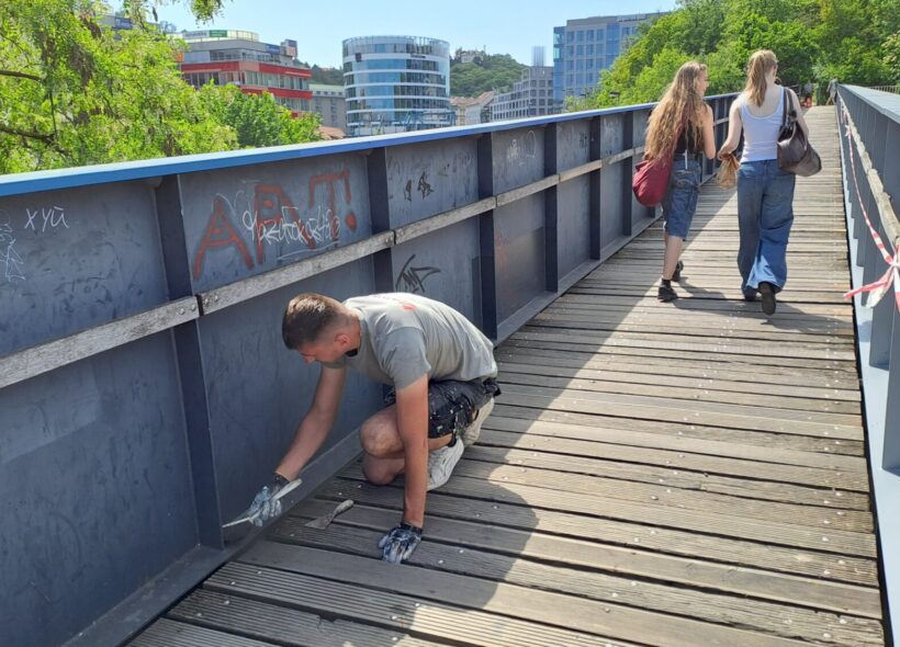 Odstraňování čmáranic z lávky, která spojuje park Sacre Coeur a nákupní centrum Nový Smíchov. 