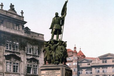 Historická podoba pomníku maršála Radeckého na Malostranském náměstí před jeho odstraněním po vzniku Československa. Počátkem listopadu 1918 byl pomník zakryt plátnem, v květnu 1919 bylo demontováno sousoší a v roce 1921 zmizel i kamenný podstavec.