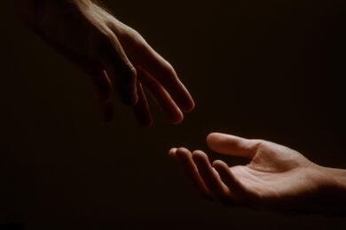 Symbolické znázornění pomoci a důvěry, kterou podvodníci zneužívají při manipulaci s transparentními účty neziskových organizací.