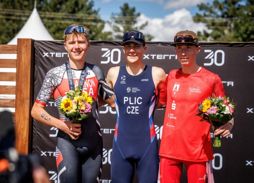 Pražský triatlonista Ondřej Plic (uprostřed) na nejvyšším stupni vítězů mistrovství světa XTERRA v americkém Ruidoso. V kategorii Youth B obhájil světový titul a druhého závodníka porazil o více než osm minut.