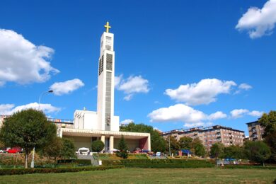 Čechovo náměstí ve Vršovicích s dominantou funkcionalistického kostela svatého Václava od architekta Josefa Gočára. Plánovaná rekonstrukce za přibližně 300 milionů korun vyvolala odpor části místních obyvatel, kteří se peticí snaží zachovat současný parkový charakter náměstí.