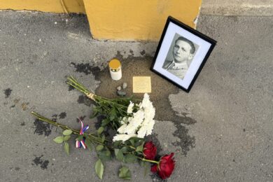 Květiny, zapálená svíčka a dobový portrét u jednoho z Kamenů zmizelých v Praze 2. Pietní místo připomíná tragický osud někdejšího obyvatele této městské části.