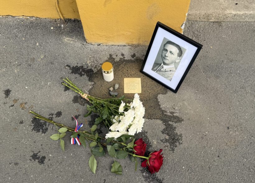Květiny, zapálená svíčka a dobový portrét u jednoho z Kamenů zmizelých v Praze 2. Pietní místo připomíná tragický osud někdejšího obyvatele této městské části.